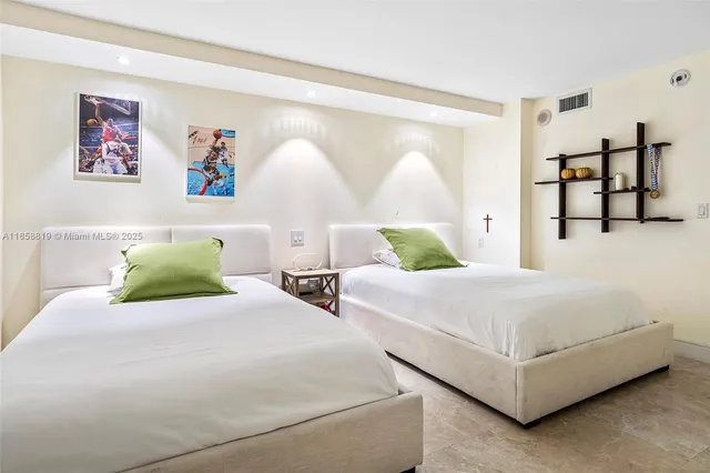 a bedroom with two beds and painting on the wall