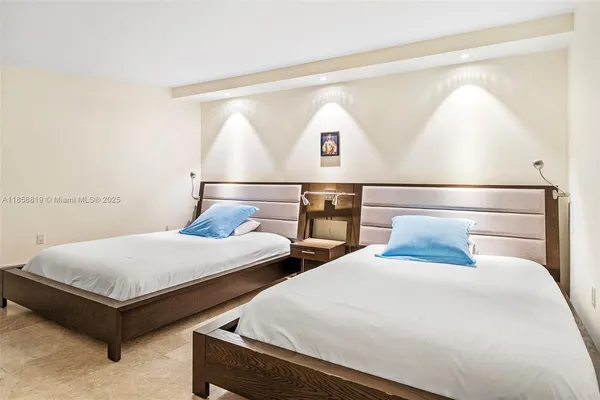 a bedroom with two beds and painting on the wall