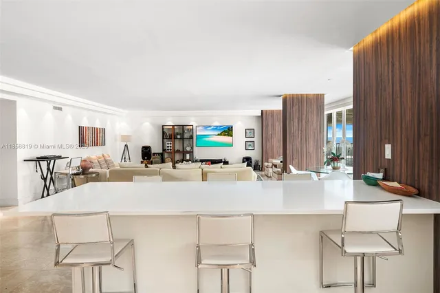 a living room with furniture a large window and kitchen view