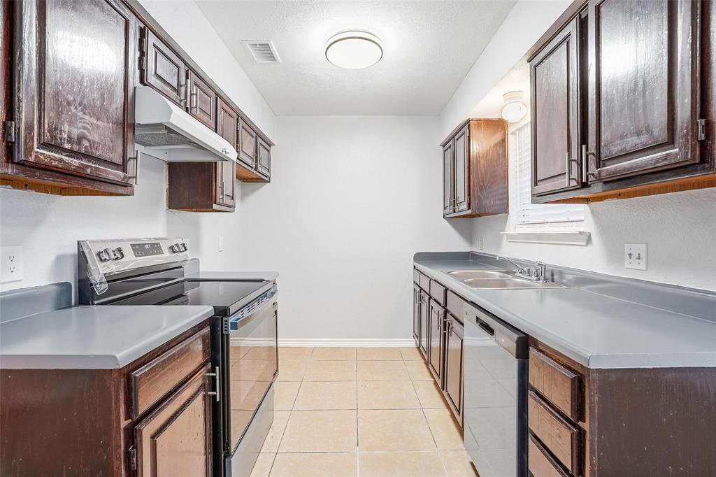 416 Colonial Place Everman, TX 76140 - Photo 27 of 39 a kitchen that has a sink and a stove