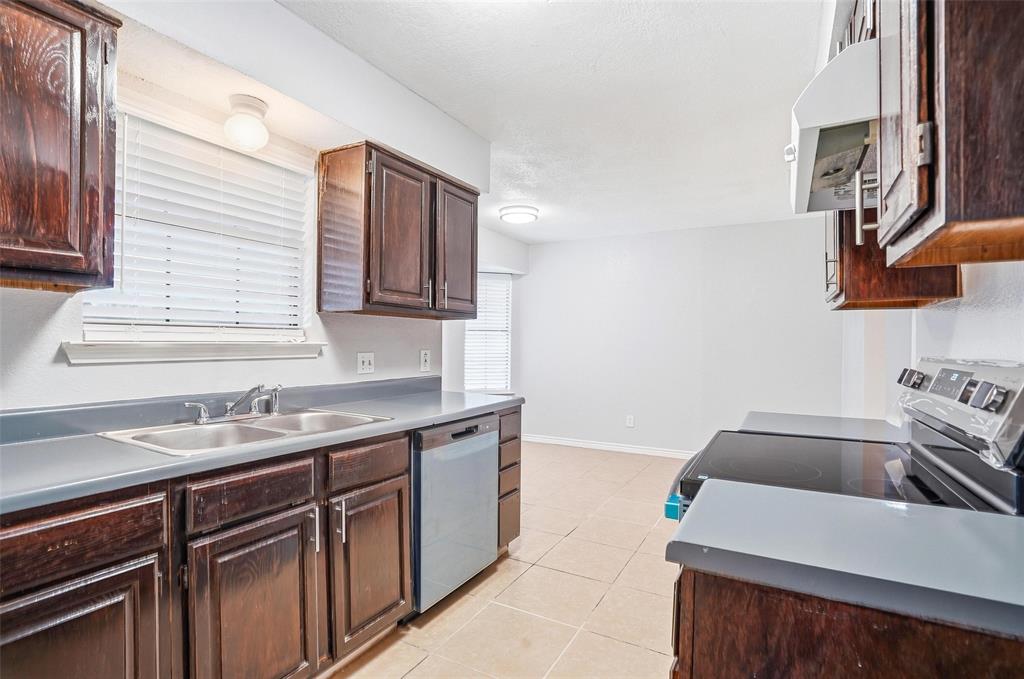 416 Colonial Place Everman, TX 76140 - Photo 30 of 39 a kitchen with a sink and a stove top oven