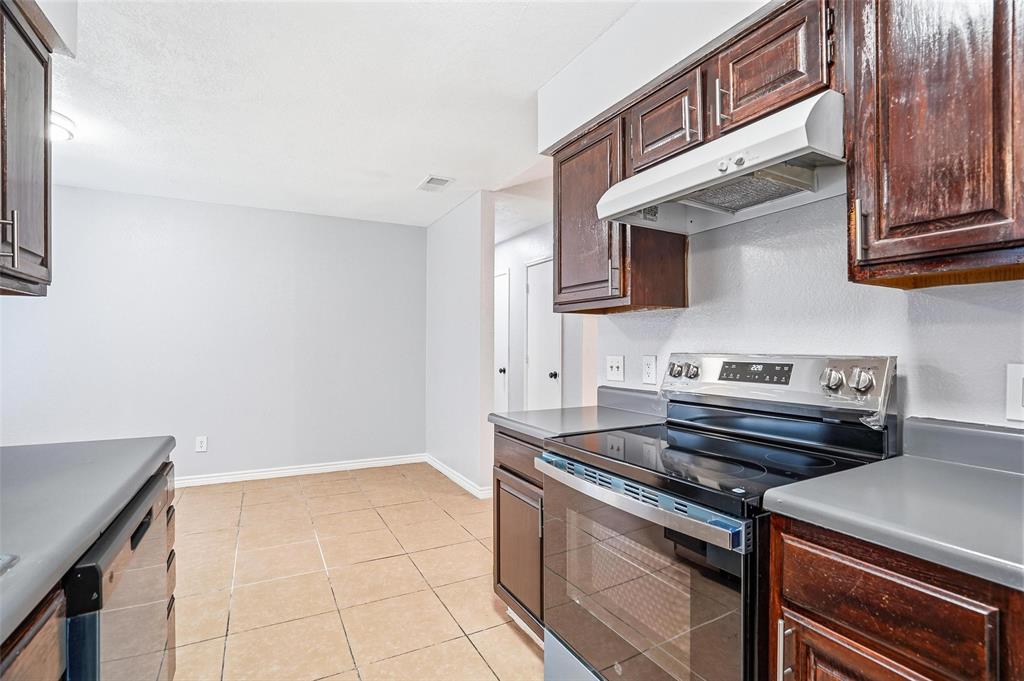 416 Colonial Place Everman, TX 76140 - Photo 31 of 39 a kitchen with a stove and a microwave