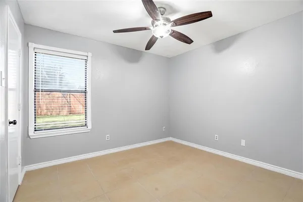 an empty room with a window and a fan