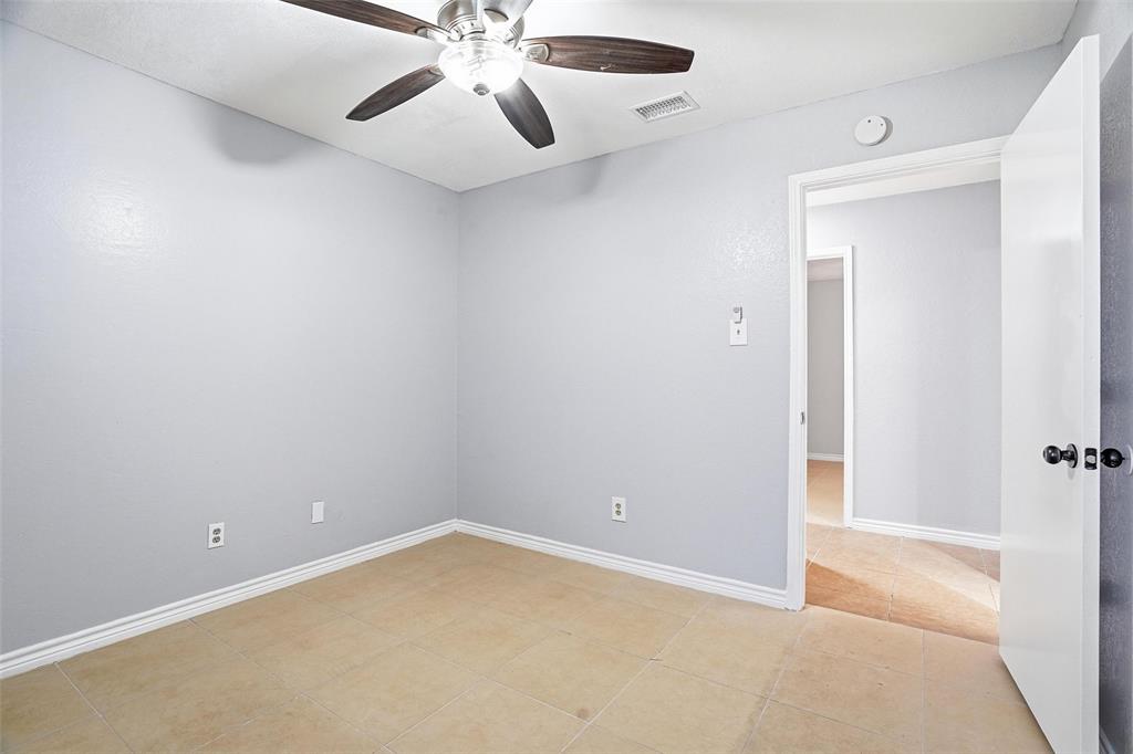 416 Colonial Place Everman, TX 76140 - Photo 8 of 39 an empty room with a chandelier fan and a bathroom