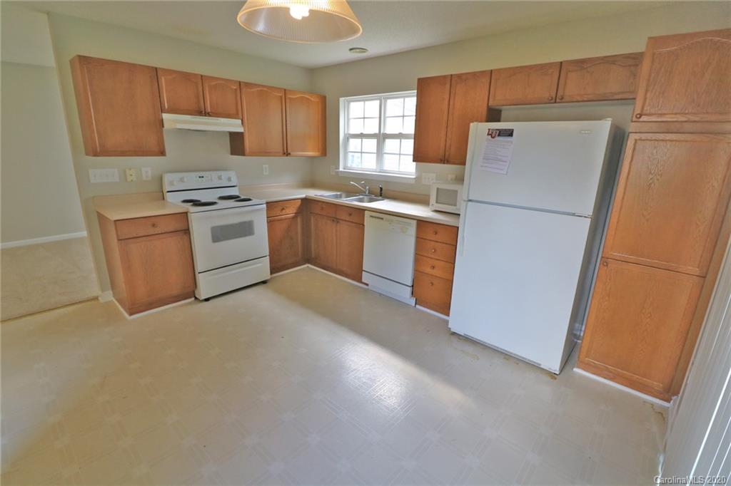 1911 Decatur Court Charlotte, NC 28213 - Photo 5 of 16 a kitchen with white cabinets and white appliances
