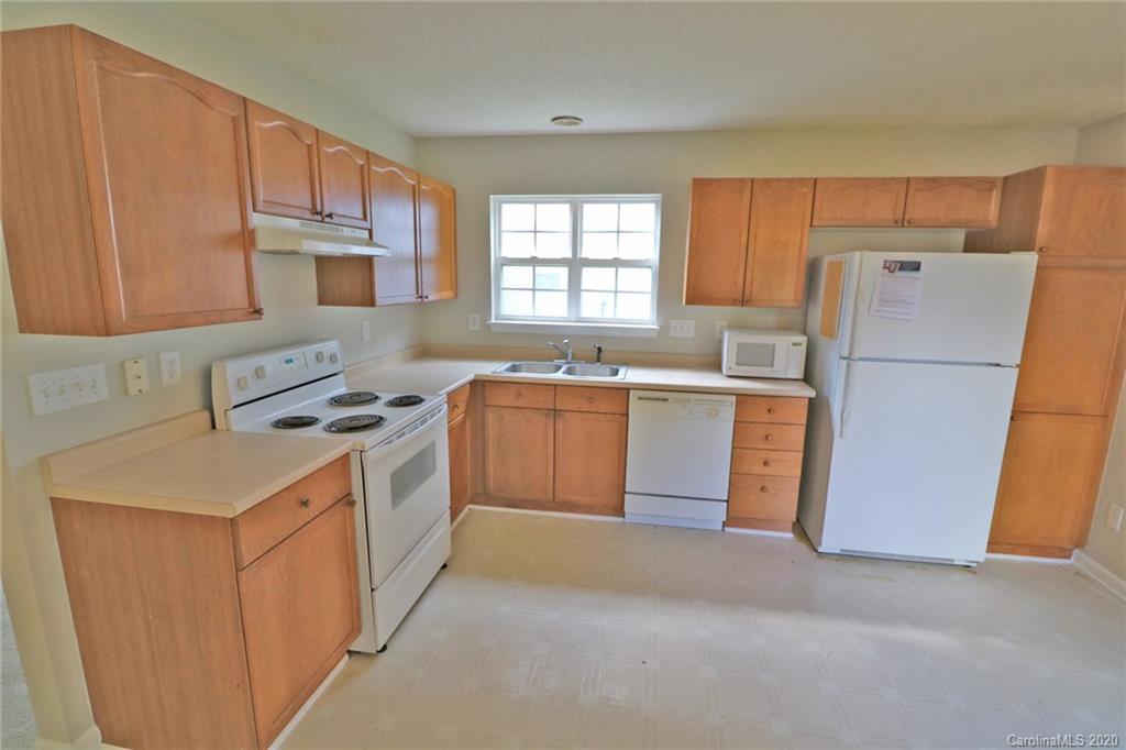1911 Decatur Court Charlotte, NC 28213 - Photo 6 of 16 a kitchen with a sink a stove a refrigerator a washer dryer and white cabinets