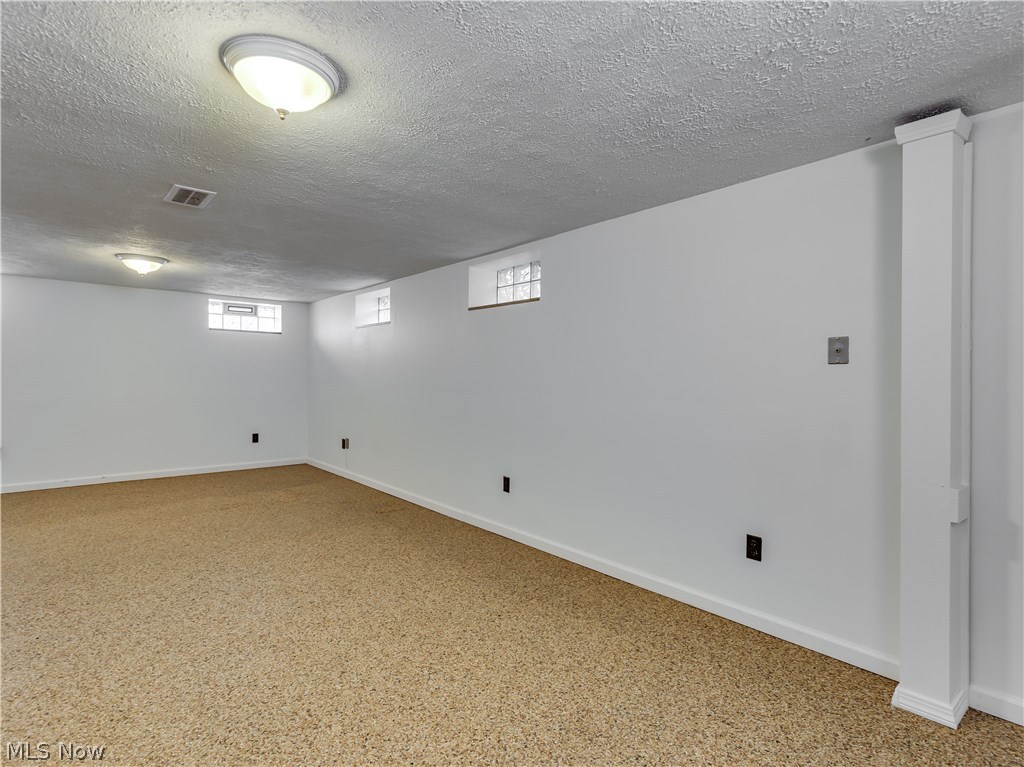 1149 Winston Road Cleveland, OH 44121 - Photo 28 of 28 Second view of the recreation room. Vented glass block windows and plenty of outlets. The other side of the basement has a work shop, laundry area and more storage.