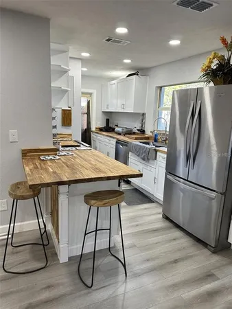 a kitchen with kitchen island white cabinets and stainless steel appliances