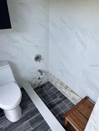 a bathroom with a toilet and a shower