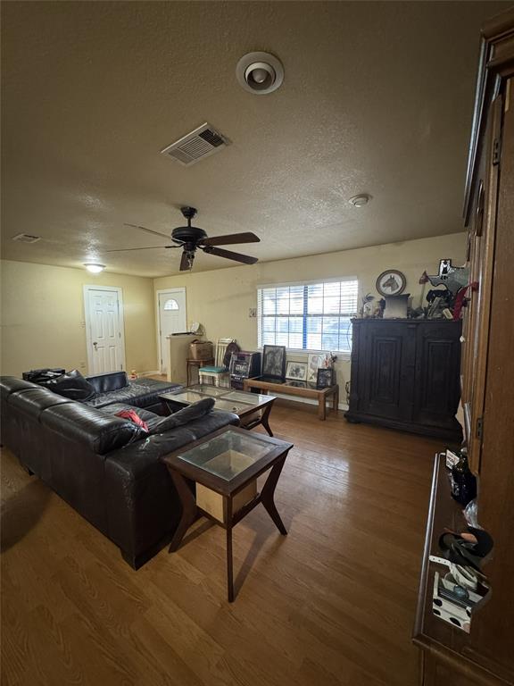 636 East Kempner Street Mabank, TX 75147 - Photo 24 of 28 Spacious living area featuring wood-finish flooring, ample natural light from multiple windows, and a ceiling fan with integrated lighting
