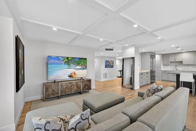 a living room with furniture kitchen view and a large window
