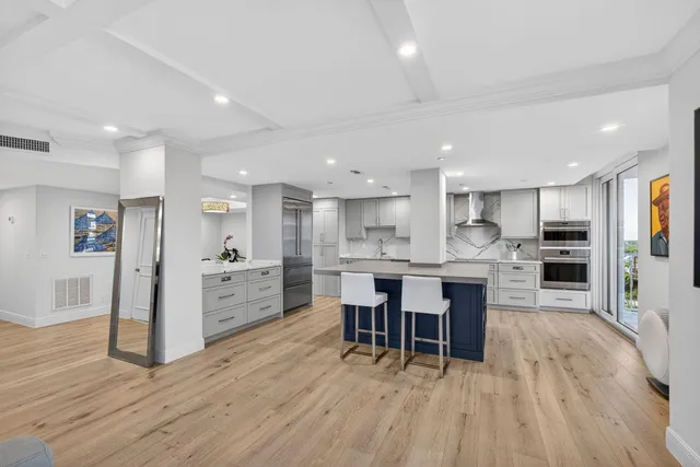 a kitchen with kitchen island granite countertop a large counter top stainless steel appliances and cabinets
