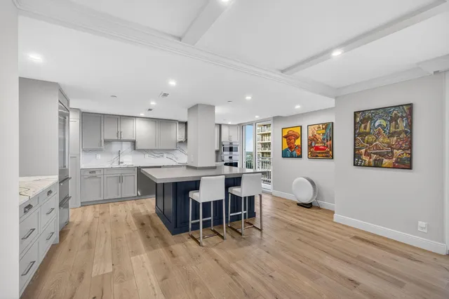 a kitchen with granite countertop a sink white cabinets and stainless steel appliances