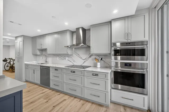 a kitchen with stainless steel appliances kitchen island granite countertop a stove a sink and a refrigerator