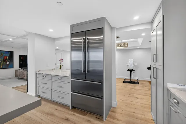a bathroom with a granite countertop sink a toilet a mirror and shower
