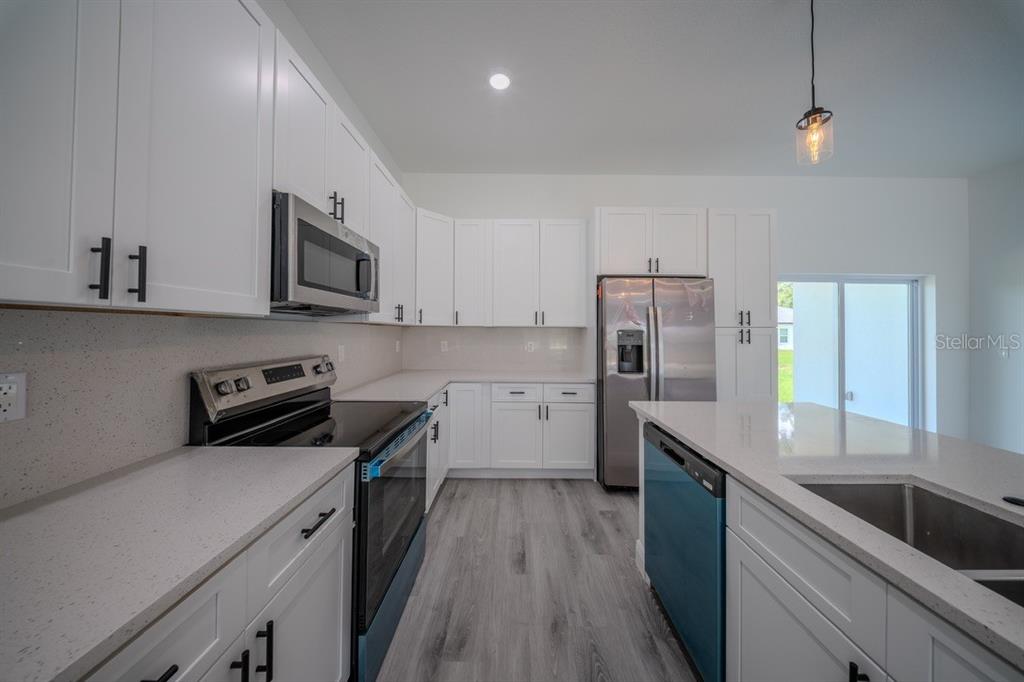 4705 Southwest 159th Lane Ocala, FL 34473 - Photo 13 of 28 a kitchen with stainless steel appliances granite countertop a sink a stove and a refrigerator