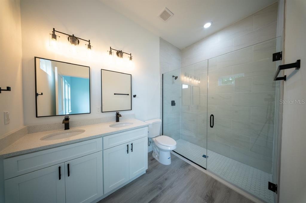4705 Southwest 159th Lane Ocala, FL 34473 - Photo 22 of 28 a bathroom with a double vanity sink toilet mirror and shower