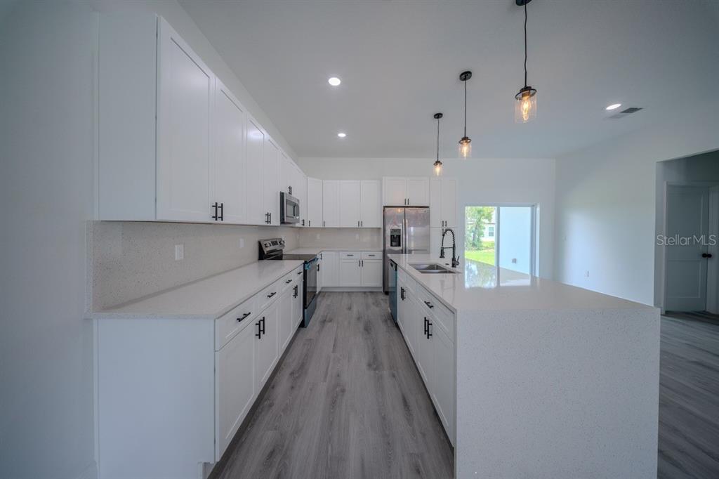 4705 Southwest 159th Lane Ocala, FL 34473 - Photo 5 of 18 a large kitchen with stainless steel appliances sink a microwave and cabinets