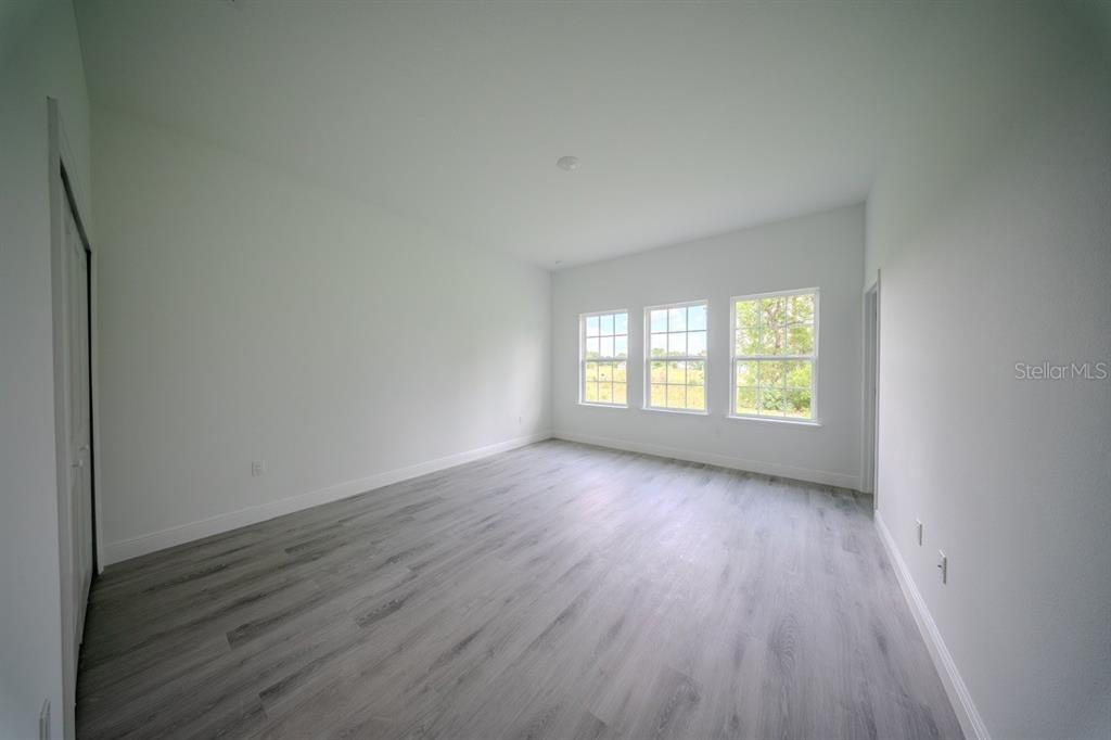 4705 Southwest 159th Lane Ocala, FL 34473 - Photo 10 of 18 an empty room with wooden floor and windows
