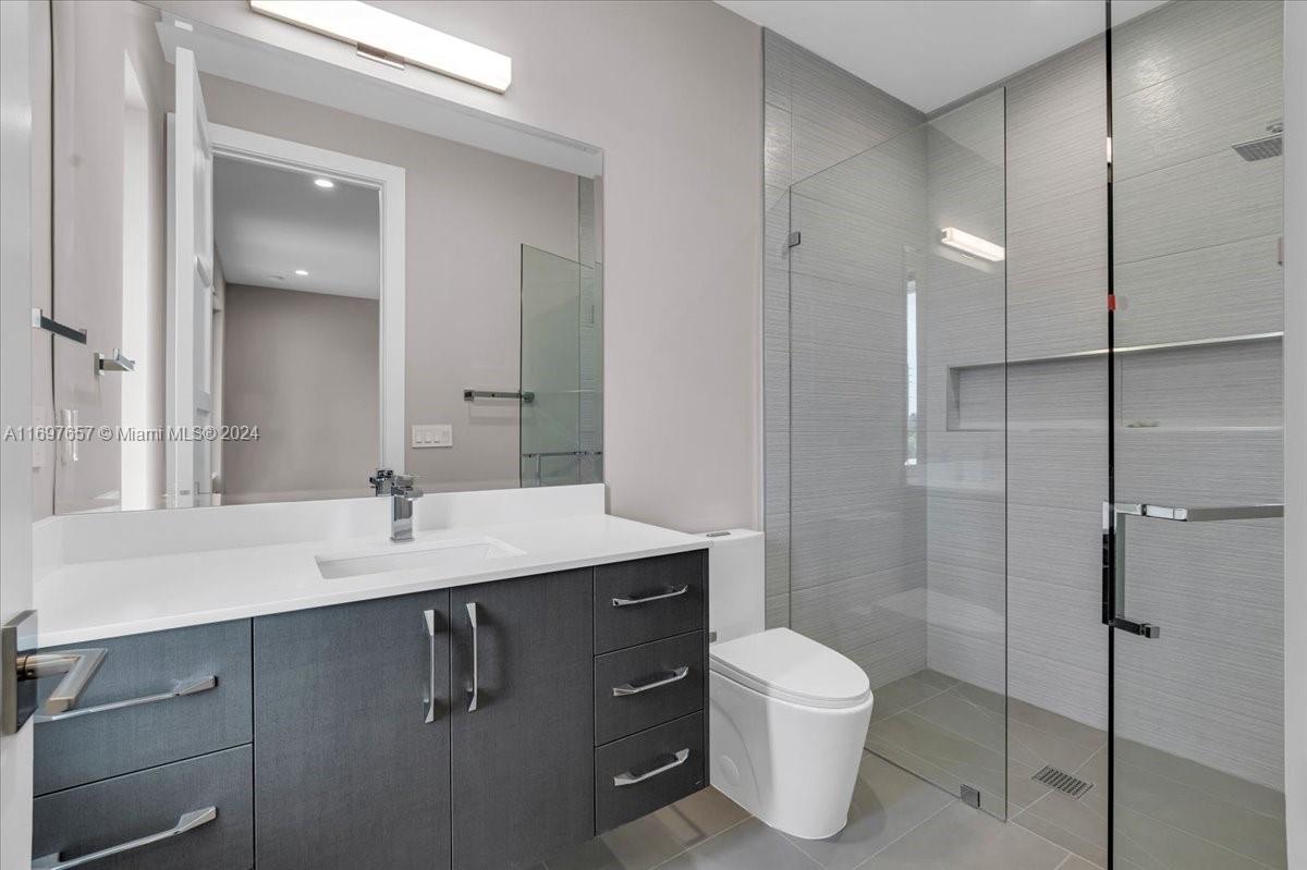 751 Northeast 2nd Street Boca Raton, FL 33432 - Photo 48 of 56 a bathroom with a granite countertop sink toilet a mirror and shower