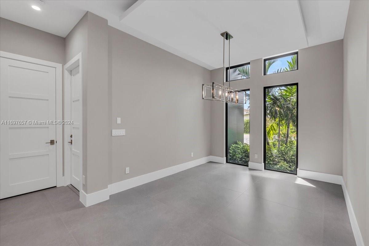 751 Northeast 2nd Street Boca Raton, FL 33432 - Photo 7 of 56 a view of a hallway with wooden floor and a chandelier