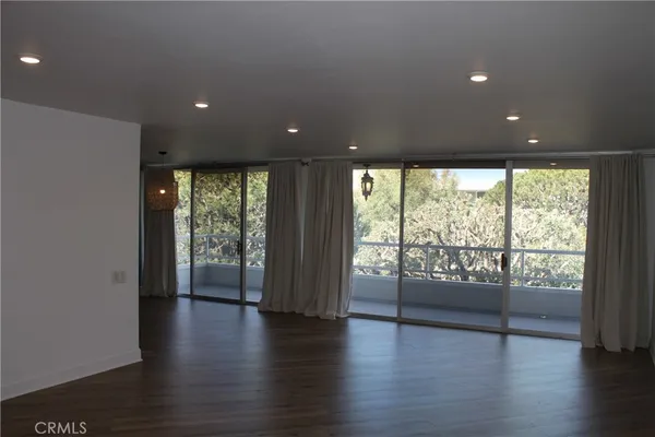 an empty room with wooden floor and sliding door