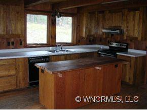 1448 Silvers Mill Road Marshall, NC 28753 - Photo 4 of 12 a kitchen with kitchen island granite countertop a sink window and cabinets