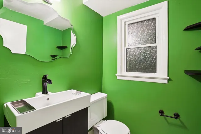 a bathroom with a toilet sink and mirror