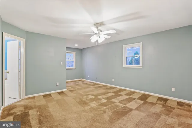 a bedroom with a fan and a chandelier fan