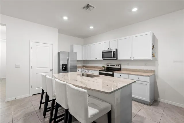 a kitchen with a sink a stove a refrigerator a microwave oven and a refrigerator