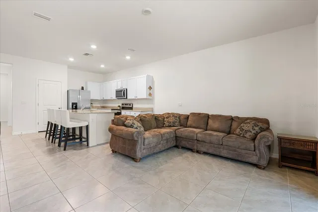 a living room with furniture and kitchen view