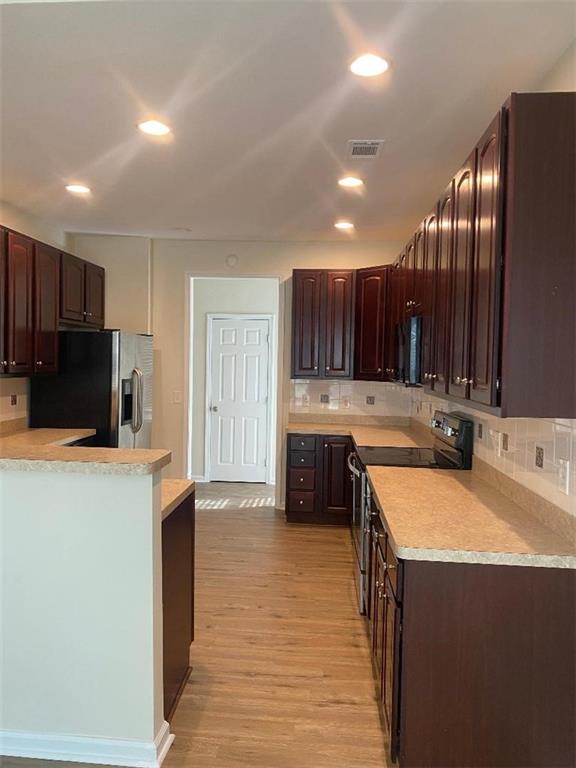539 Greyhawk Way Fairburn, GA 30213 - Photo 4 of 13 a kitchen with stainless steel appliances a sink a stove a refrigerator a center island and a stove