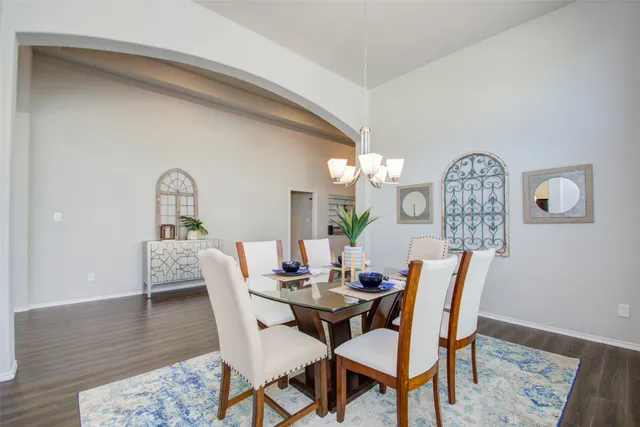 a kitchen with stainless steel appliances granite countertop a stove top oven a sink dishwasher a refrigerator and a cabinets with wooden floor