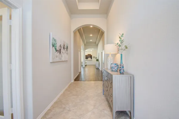 a view of a hallway with wooden floor and a living room