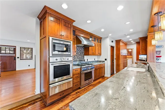 a view of a kitchen with stainless steel appliances granite countertop a stove and a refrigerator