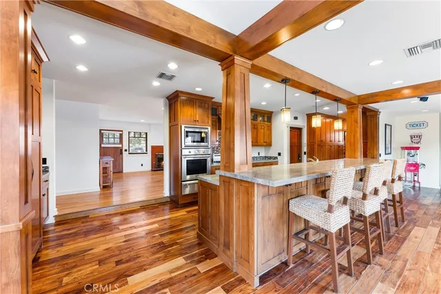 a kitchen with stainless steel appliances kitchen island granite countertop a table chairs and a refrigerator