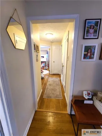 a view of a hallway with wooden floor and a workspace