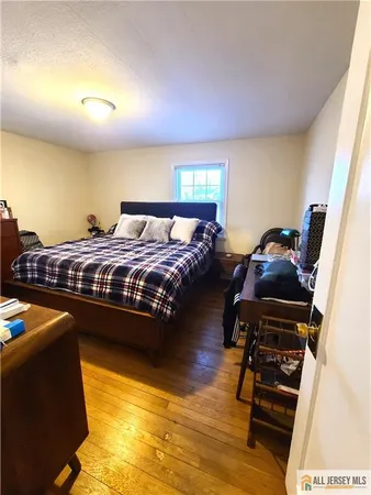 a bedroom with bed and wooden floor
