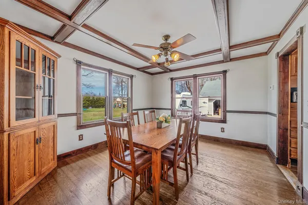 a dining room with furniture a chandelier and wooden floor