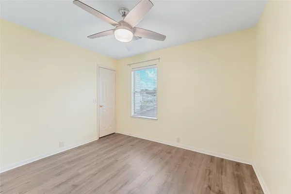 an empty room with wooden floor and window