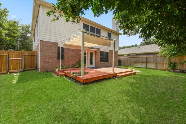a view of a house with a backyard and a tree