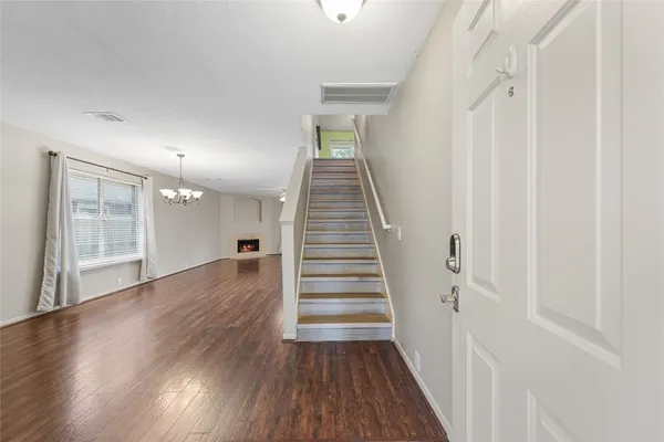 a view of a hallway with wooden floor and entryway