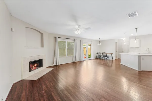 a view of a livingroom with wooden floor and a fireplace