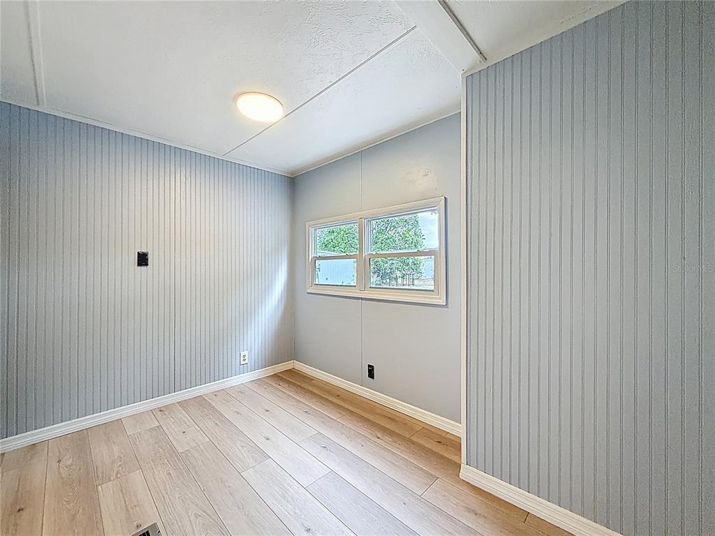 9569 Gray Fox Drive Weeki Wachee, FL 34613 - Photo 13 of 27 a view of empty room with wooden floor