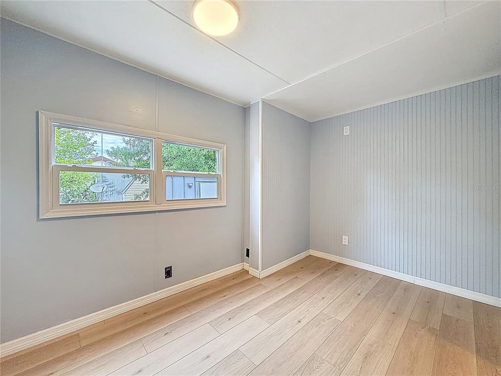 9569 Gray Fox Drive Weeki Wachee, FL 34613 - Photo 15 of 27 a view of empty room with wooden floor and fan