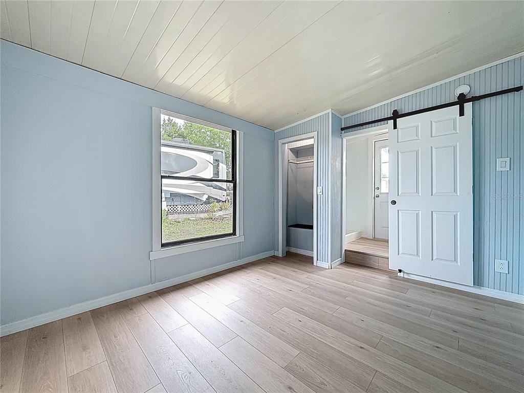 9569 Gray Fox Drive Weeki Wachee, FL 34613 - Photo 18 of 27 a view of an empty room with wooden floor and a window