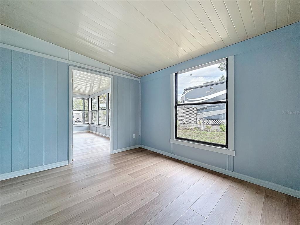 9569 Gray Fox Drive Weeki Wachee, FL 34613 - Photo 19 of 27 an empty room with wooden floor and windows