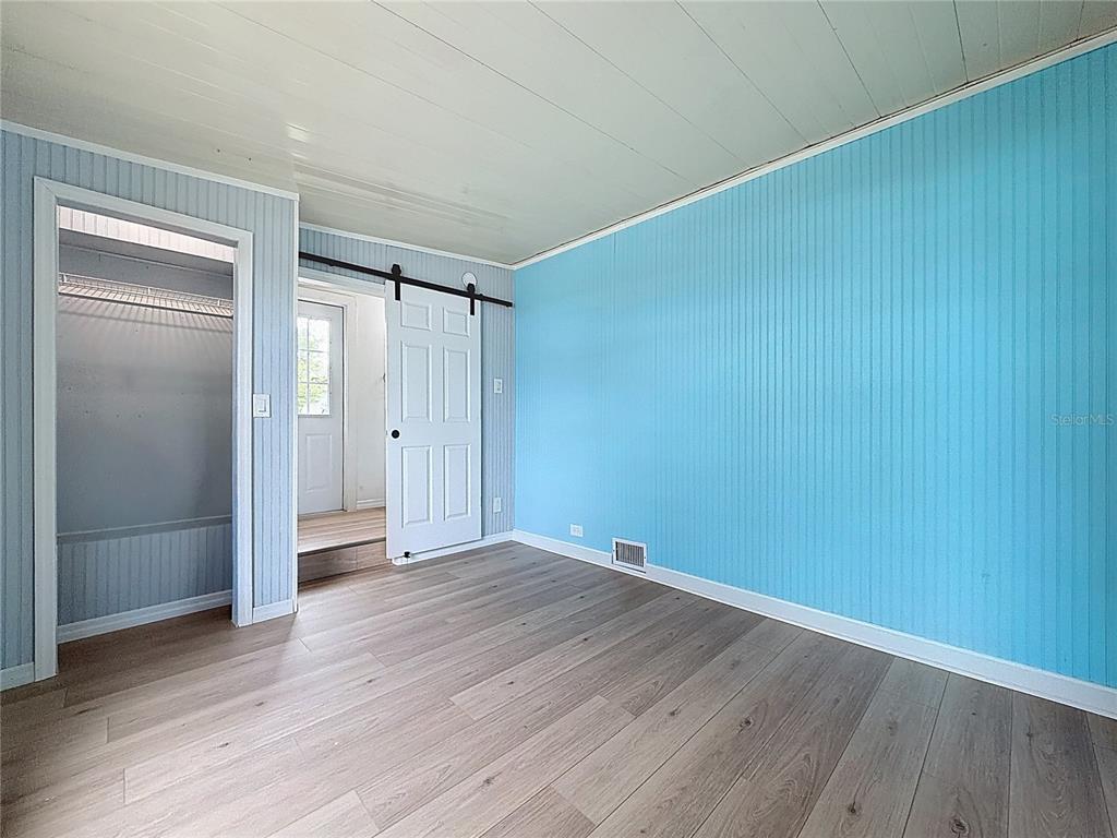 9569 Gray Fox Drive Weeki Wachee, FL 34613 - Photo 20 of 27 a view of an empty room with wooden floor