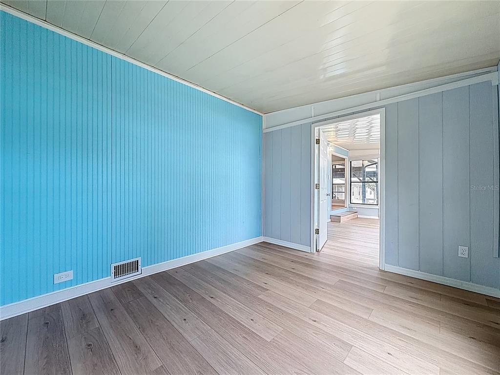 9569 Gray Fox Drive Weeki Wachee, FL 34613 - Photo 21 of 27 an empty room with wooden floor and windows