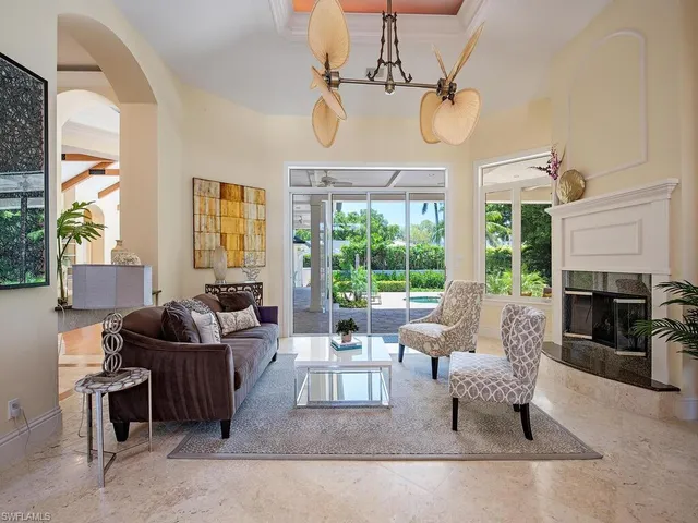 a living room with furniture a fireplace and a chandelier